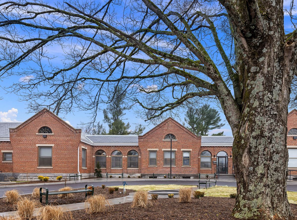 Restored brick campus building under a blue sky, Huber Architects